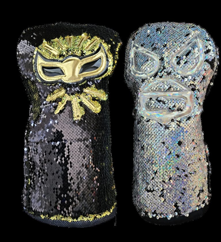 Two sequined hand warmers or clutches with lucha libre wrestling mask designs, one in black and yellow, the other in silver with iridescent sequins