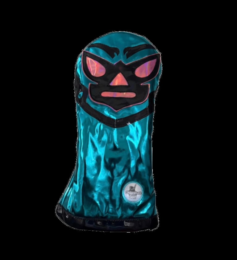 Teal and black stylized head plush toy with glowing pink eyes and mouth on dark background
